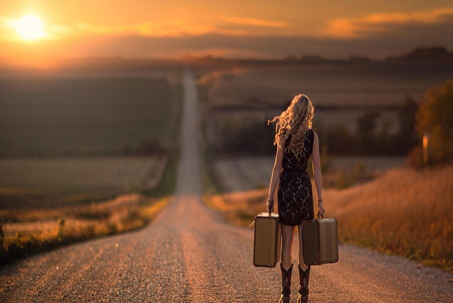 Woman walking into the distance at sunset, symbolizing the journey of manifesting a dream into reality.