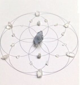 Angelic crystal grid with aquamarine and clear quartz on a sacred geometry layout.