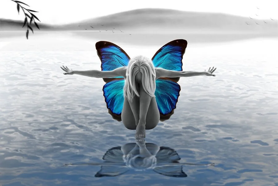 Woman with butterfly wings kneeling over water, symbolizing spiritual awakening