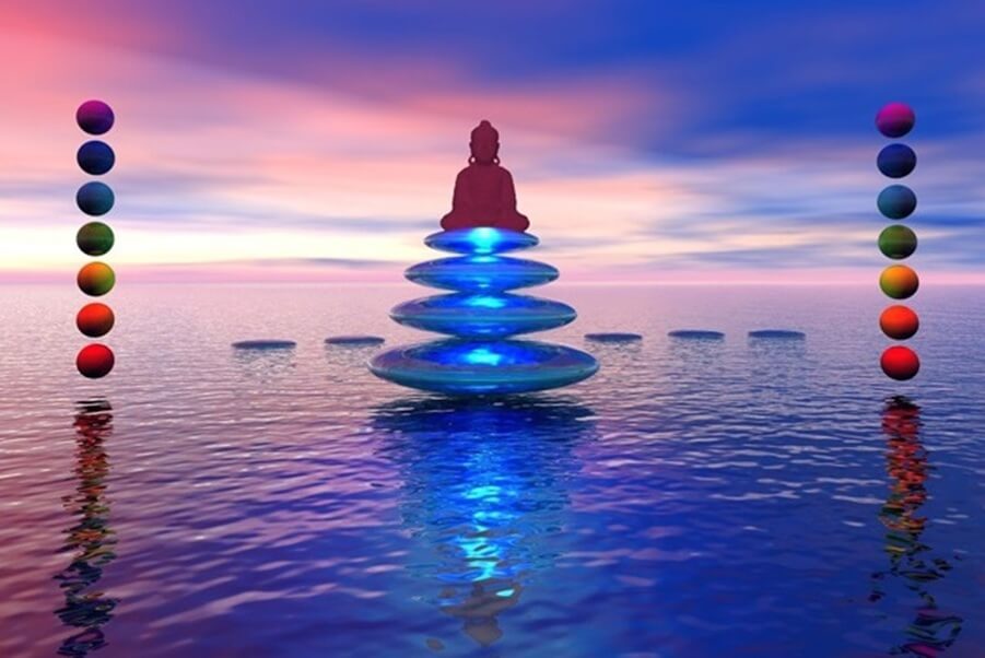 Chakra Balancing and energy healing meditation with healing stones and Buddha silhouette over water