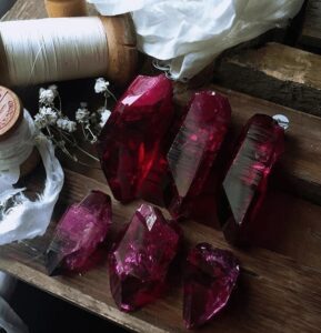 Ruby Aura Quartz crystals with deep red color and metallic sheen used in aura healing sessions