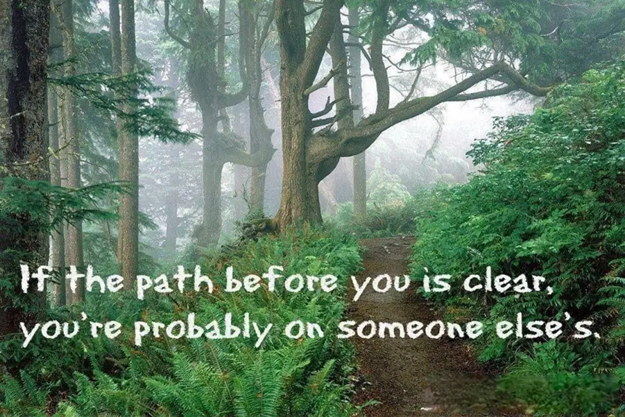 Forest trail with inspirational quote about finding your own path instead of following others.