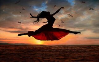 Woman leaping with joy at sunrise symbolizing inner empowerment and strength within