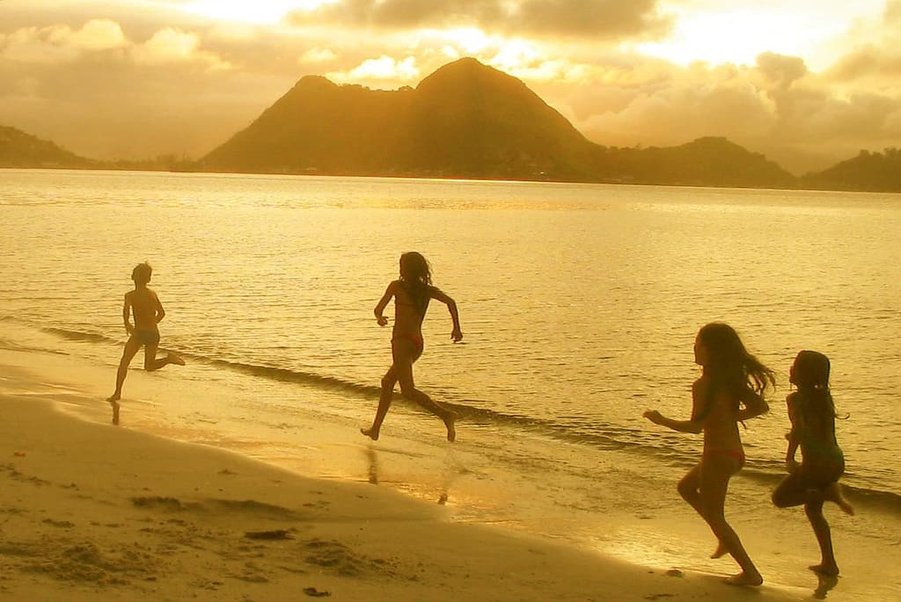 Children playing on the beach at sunset symbolizing our lives, our voices, and authentic self-expression.