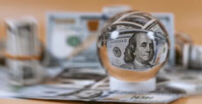 Crystal ball focused on hundred dollar bill symbolizing financial psychic insights