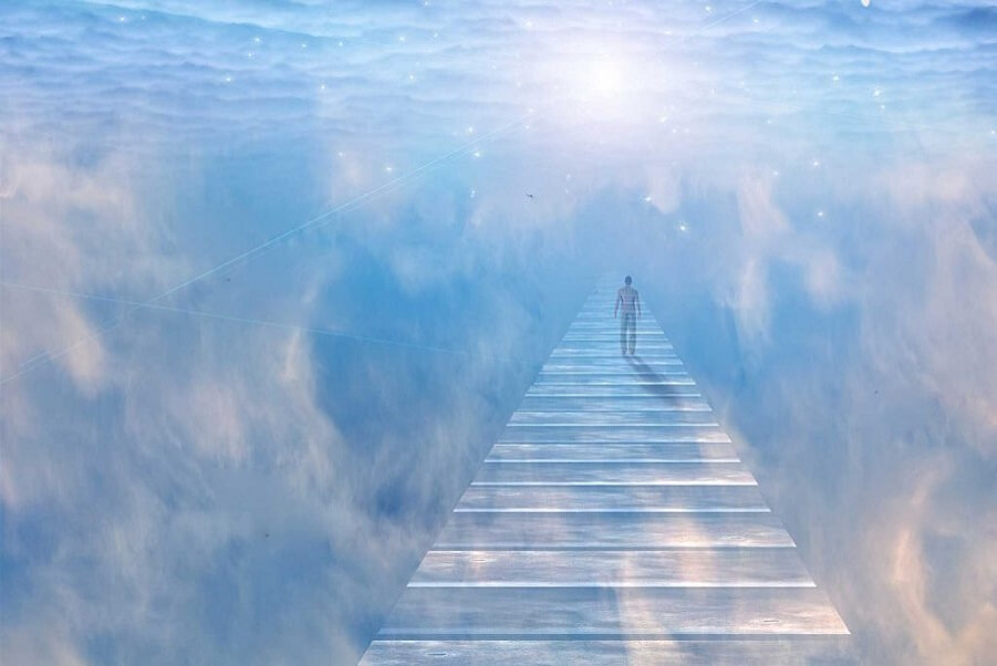 Person walking into peaceful light surrounded by clouds, symbolizing the soul's transition at end of life