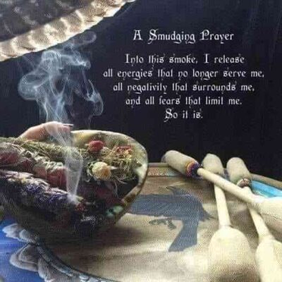 Smudging prayer ritual with sage smoke rising in a sacred abalone shell