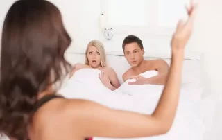 A woman catching her partner in an affair, symbolizing the emotional and karmic complexities behind infidelity.